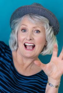 Photo of Cathy Towers, a woman wearing a blue and black striped top and hat